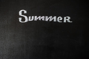 Text Summer written with chalk on chalkboard
