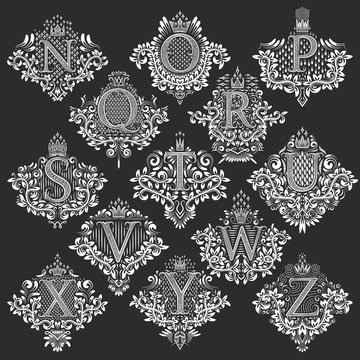 Set of heraldic monograms in coats of arms form. White floral decorative stamps of letters from N to Z. Isolated tattoo labels in vintage baroque style.