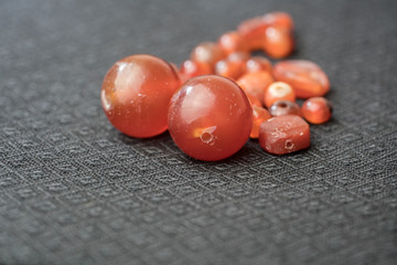 Varieties of ancient carnelian beads on Thai silk background