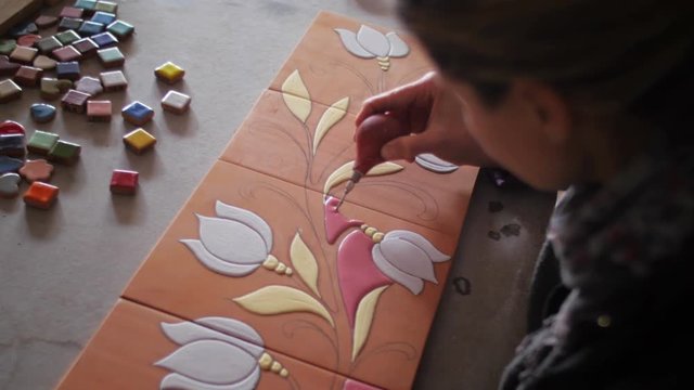 Ceramic maker filling pencil strokes on terracotta with rubber bulb