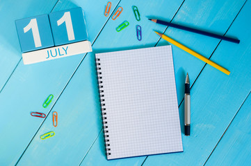 July 11th. Image of july 11 wooden color calendar on blue background. Summer day. Empty space for text. World Chocolate Day