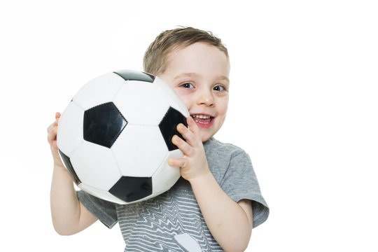 Cute boy is holding a football ball isolated on a white background. Soccer