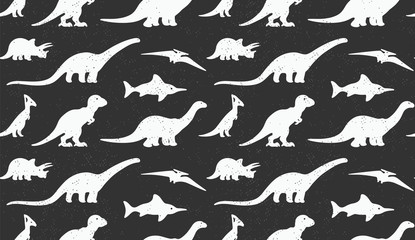 Dinosaurs white silhouettes on black background. Seamless pattern