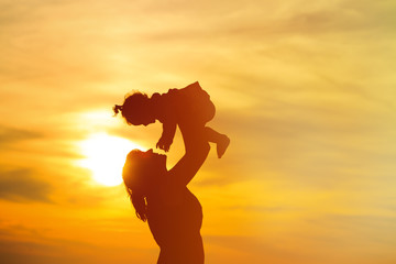 Fototapeta premium mother and little daughter play at sunset