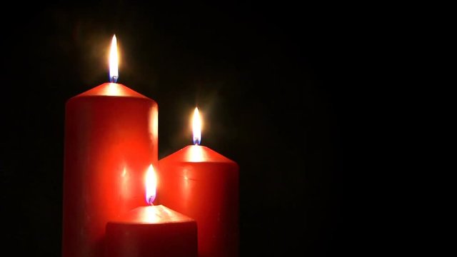 Christmas 0101: Three red candles burning against a black background (Loop).