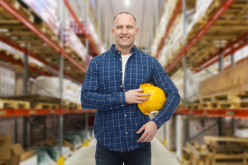 happy man with hardhat over warehouse