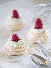 Meringue cakes Pavlova with whipped cream and fresh raspberries