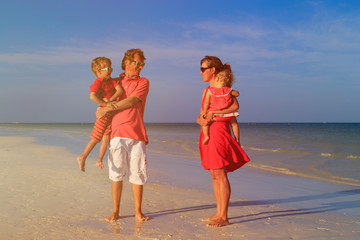 Young family with two kids walking at beach