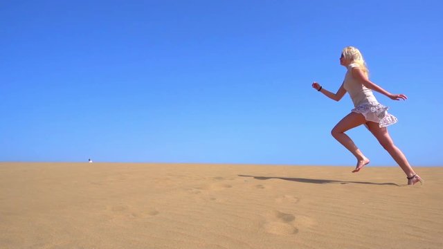 Young Woman In short skirt Running On Desert, Slow Motion