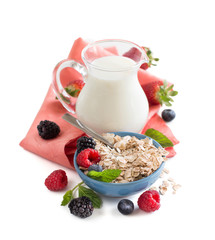 Rolled oats in a bowl with berries and milk