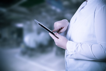 A woman in a white uniform robe with electronic device in her ha