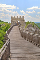 Stone walls and gate with wooden bridge of medieval fortress