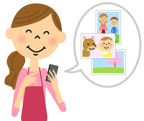 スマートフォンを触るエプロンの女性 