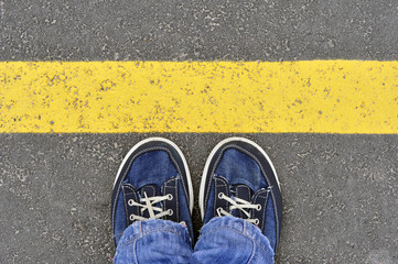 Top View of Male shoes on the asphalt road with yellow line, Ste