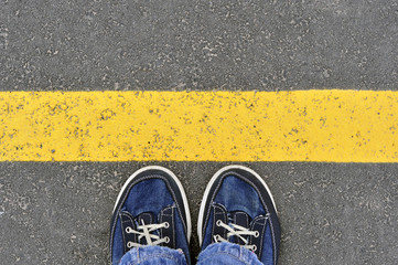 Top View of Male shoes on the asphalt road with yellow line, Ste
