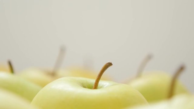 Juicy and healthy fresh apple fruit background with petioles slow tilt 4K 3840X2160 30fps UltraHD video - Tilting on yellow apples with penducles in a row 4K 2160p UHD footage 