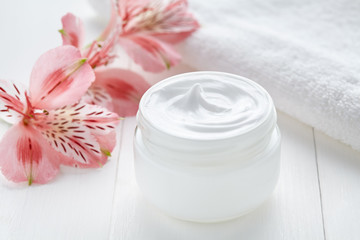 Obrazy na Szkle  Naturalny krem do twarzy dermatologia produkt kosmetyczny wellness i relaksacyjna maska do makijażu w szklanym słoju z ręcznikiem na białym tle