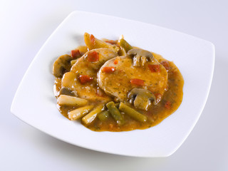 Filets in sauce with beans, peppers and asparagus on white background