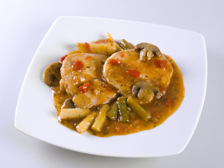 Filets in sauce with beans, peppers and asparagus on white background