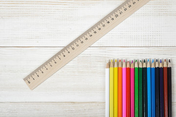 Top view of different colored wooden pencils with centimeter ruler