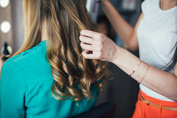 In the beauty salon, make-up artist doing make-up, hairdresser doing hairstyle, beautiful models