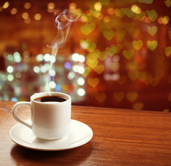 Obraz premium Cup of coffee on table on blured cafe background