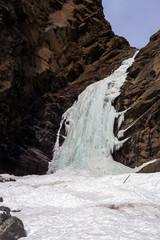 Icy waterfall at rock cliff in winter time