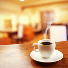 Cup of coffee on table on blured cafe background