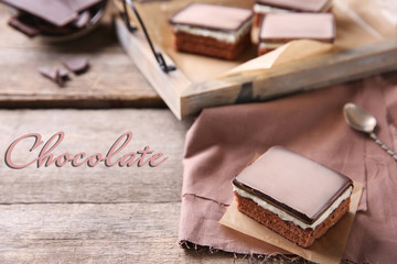 Delicious chocolate brownies on tray, on wooden background