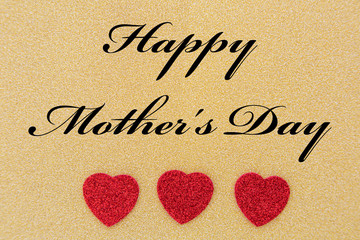 drei Herzen und ein Text f&uuml;r den Muttertag auf goldenem Hintergrund