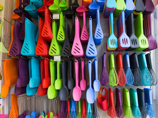 Bunte Küchenutensilien an der Wand, mit Haken befestigt
