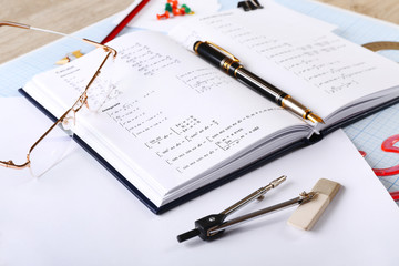Naklejka premium School supplies and textbook on mathematics close up