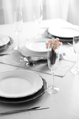 Table set at restaurant on light background