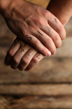 Tattoo inscriptions on male fingers drawn with marker