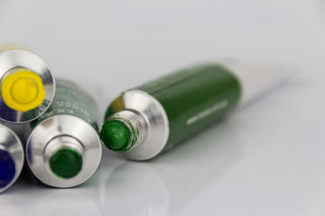 color paint tubes macro on white background