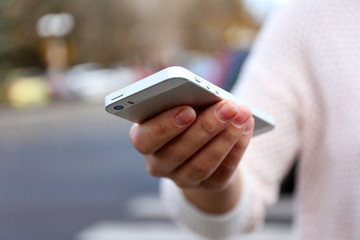 Woman holding smartphone outside
