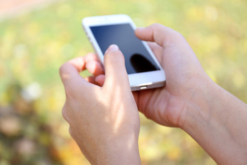 Woman holding smartphone outside
