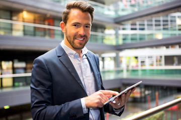 Young attractive business man using tablet