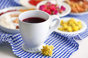 Cup of tea with aromatic dry tea on wooden background