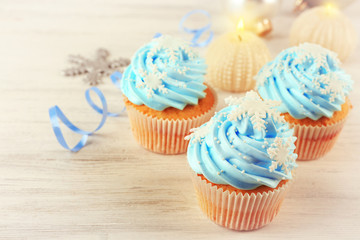 Few tasty blue cupcakes with decorations on light background