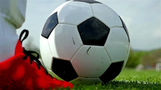 Football game. Soccer action. Goal keeper/footballer kicking a ball, slow motion