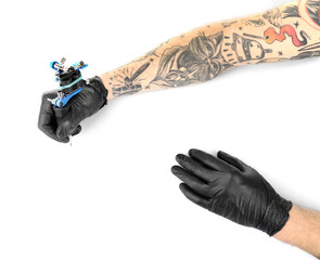 Tattooist hands in black gloves with tattoo machine isolated on white background, close up
