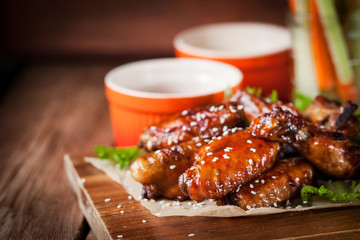 Hot chicken wings cooked with honey and soy,  topped with sesame