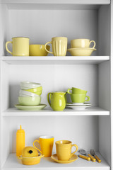 Fototapeta na wymiar Tableware on shelves in the kitchen cupboard