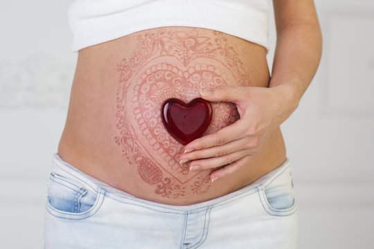 Woman's Pregnant Belly With Henna Tattoo 