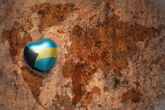 heart with national flag of bahamas on a vintage world map crack paper background. concept