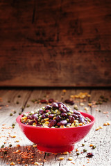 Bean mix: purple beans, green and red lentils, dry peas in a red
