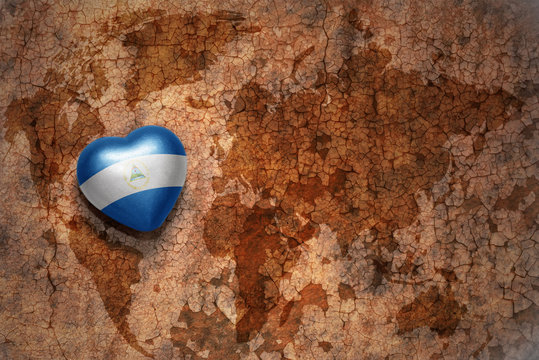 heart with national flag of nicaragua on a vintage world map crack paper background. concept