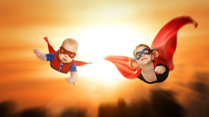 children superheroes flying across sunset sky
