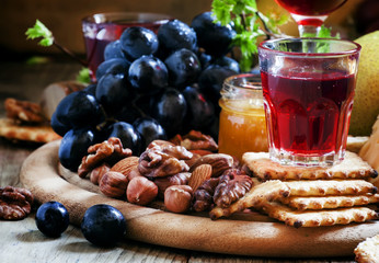 Rose wine and wooden dish with various snacks, vintage backgroun
